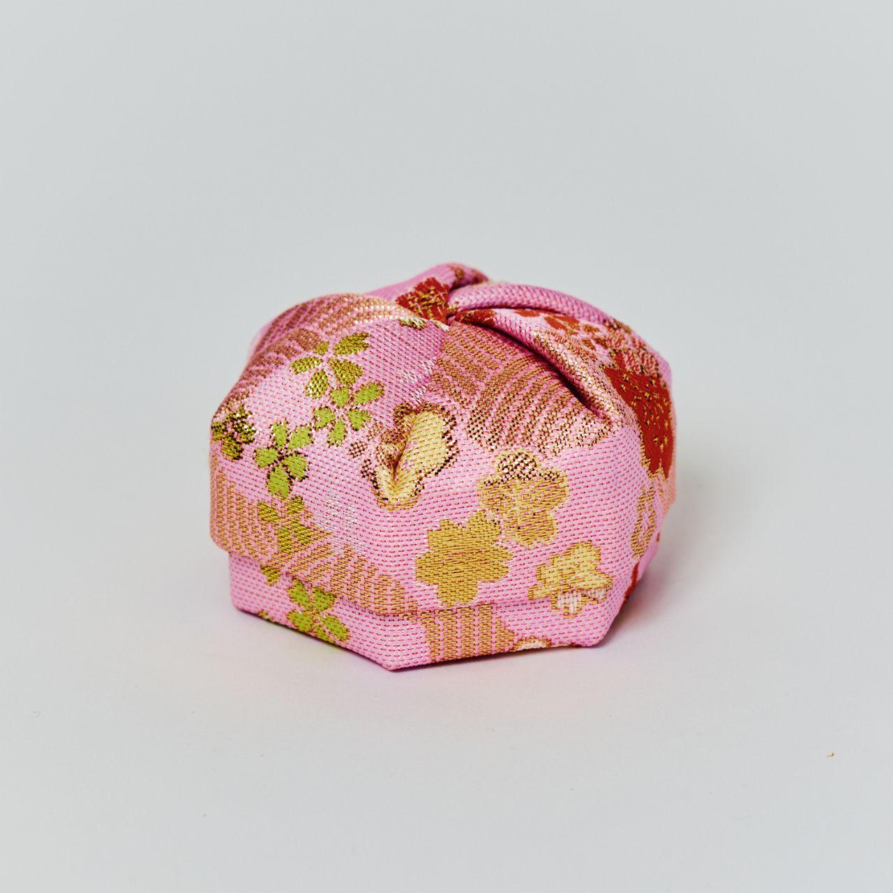 A hexagonal Japanese jewelry box made of pink vintage silk with gold floral patterns, traditionally known as Nuno-Kogo.