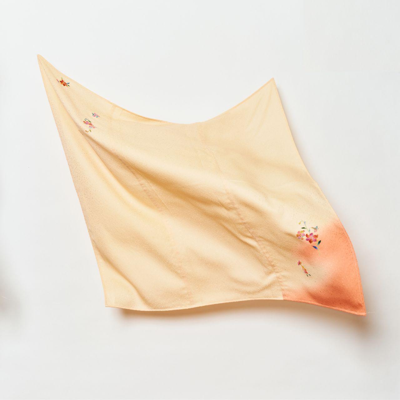 A flowing, lightweight Japanese silk cloth in pale peach and crimson gradient, featuring delicate hand-painted floral patterns and a subtle textured finish.
