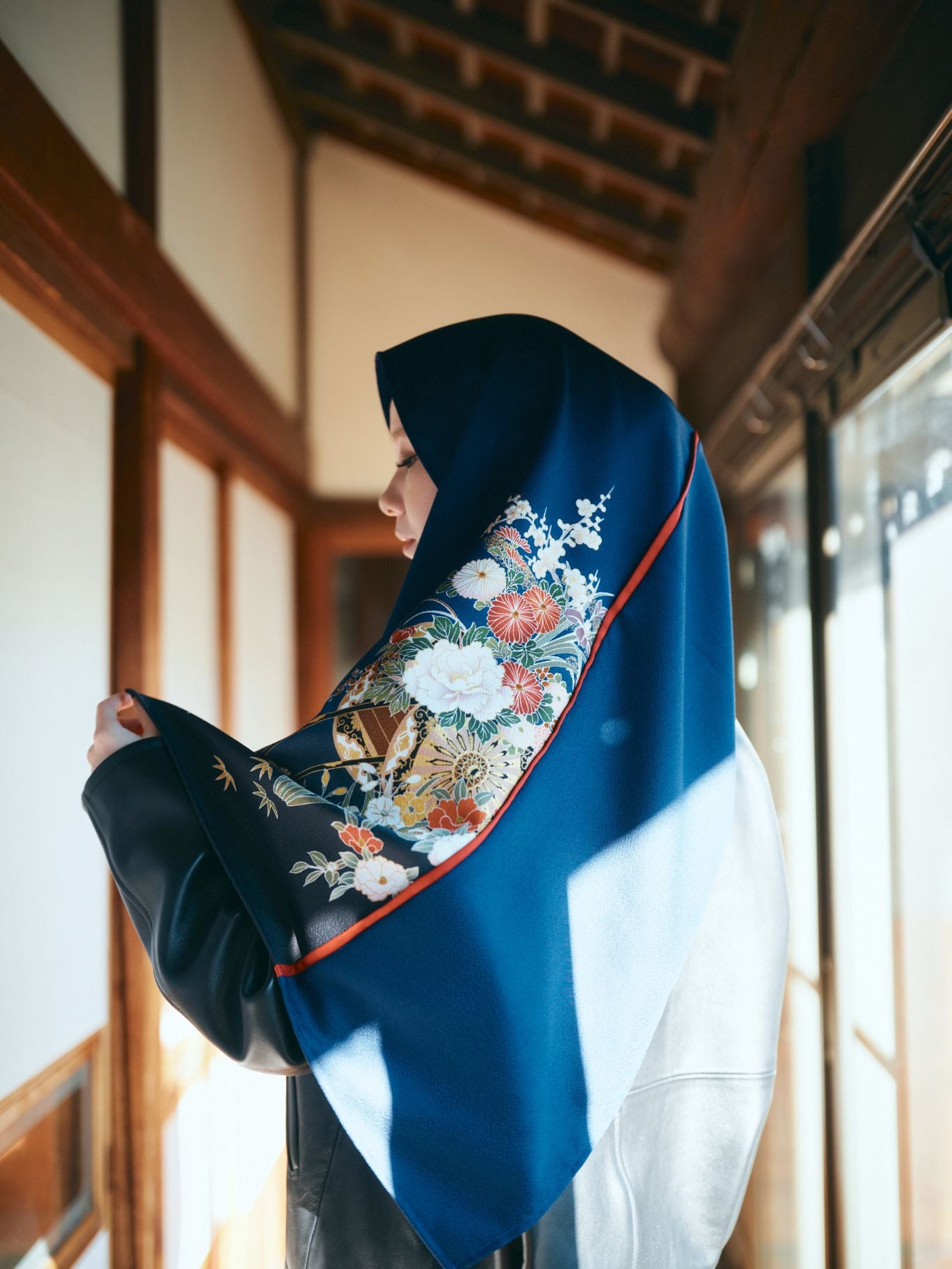A woman wearing a luxury MOMO & NANA hijab handcrafted from vintage Furisode kimono silk, featuring vibrant floral patterns and elegant Japanese drapery.